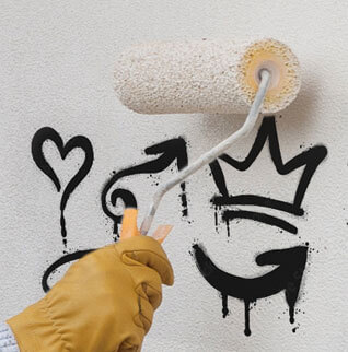 Graffiti wird mit Malerrolle entfernt