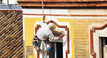 Maler streicht Hausfassade
